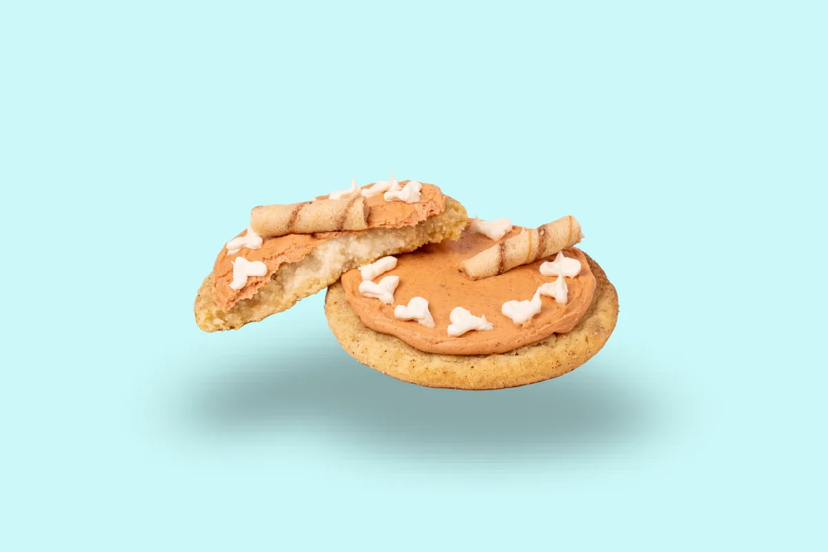 Dirty Dough Spiced Chai Snickerdoodle: a chai-spiced sugar cookie with a sweet cream center, chai frosting, buttercream drizzle, and a Pirouline wafer